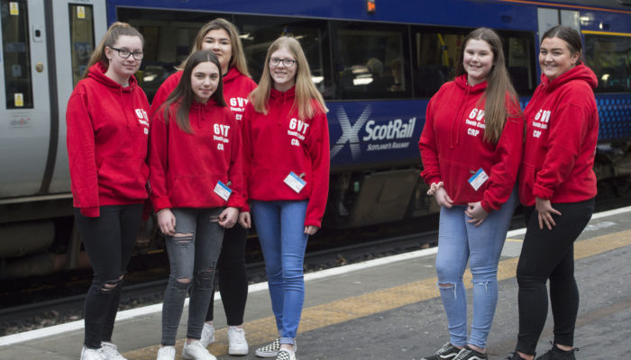 Group of young people stood by a train